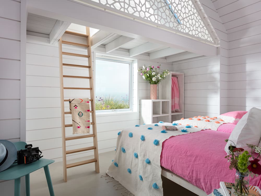 Спальня Three Mile Beach с розовыми простынями и лестницей